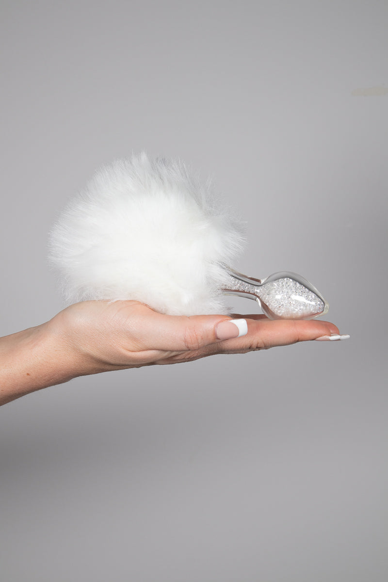 Right hand with the white magnetized fuax fur tail lying in palm