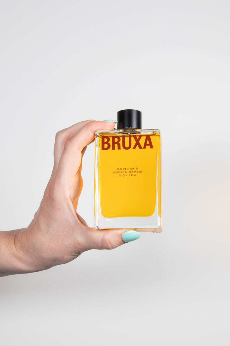 Fingers holding a Bruxa Oil of Winter bottle