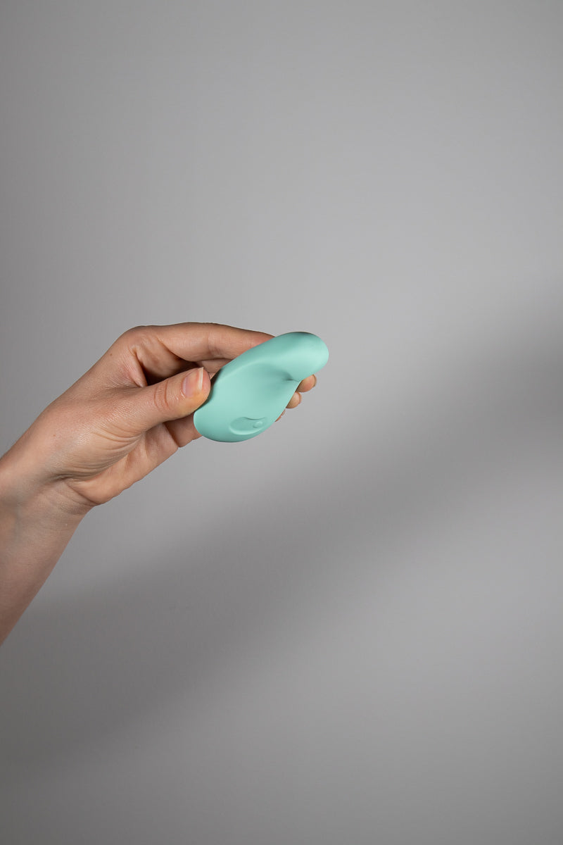 Dam Pom Jade vibrator held in hand showing bottom side of sex toy 