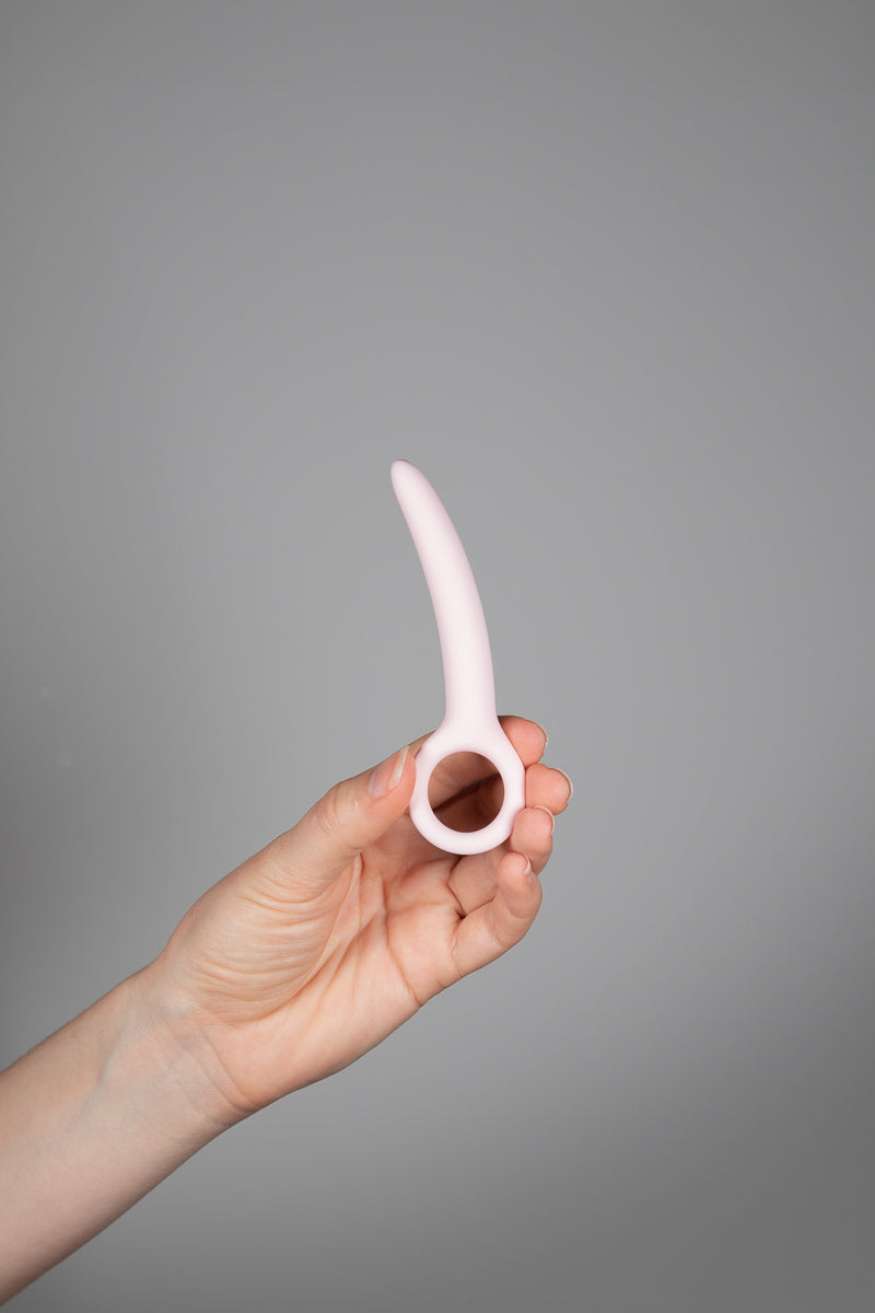 A Hand holding the small dilator upright