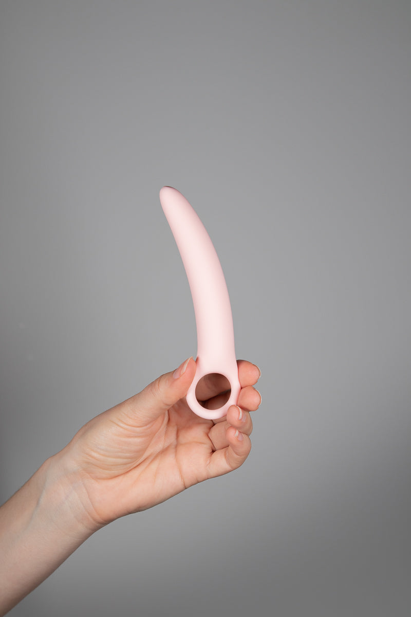 A Hand holding the second largest dilator upright 