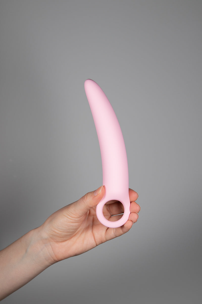 A hand holding the largest dilator upright 
