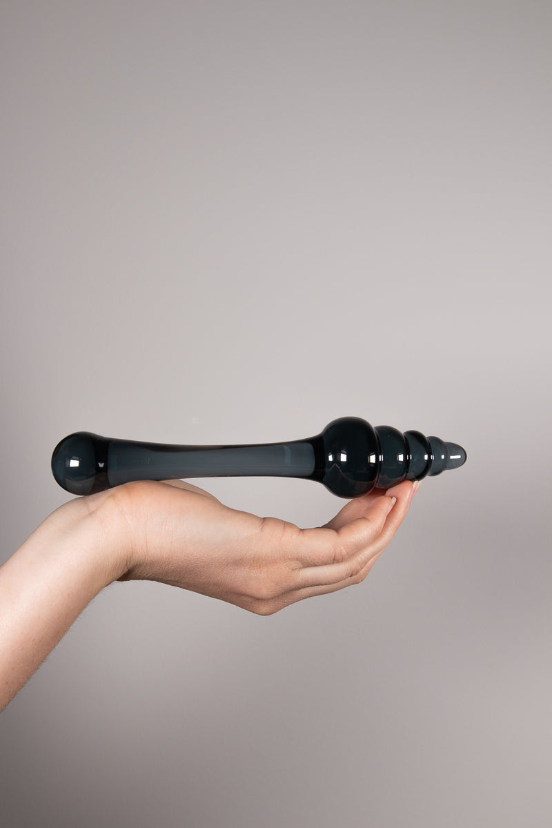 A bent hand holding the Beam sex toy horizontal