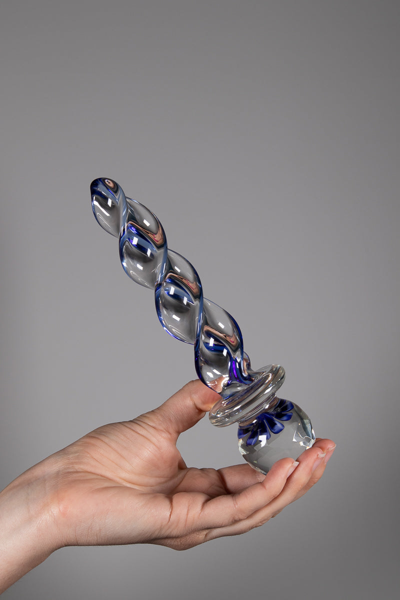 Faceted implosion sex toy held diagonally upright in hand 