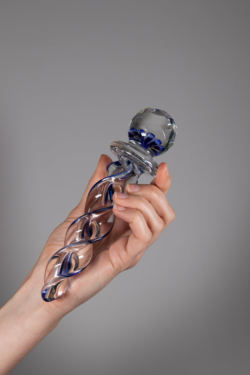Faceted implosion sex toy held via shaft in hand