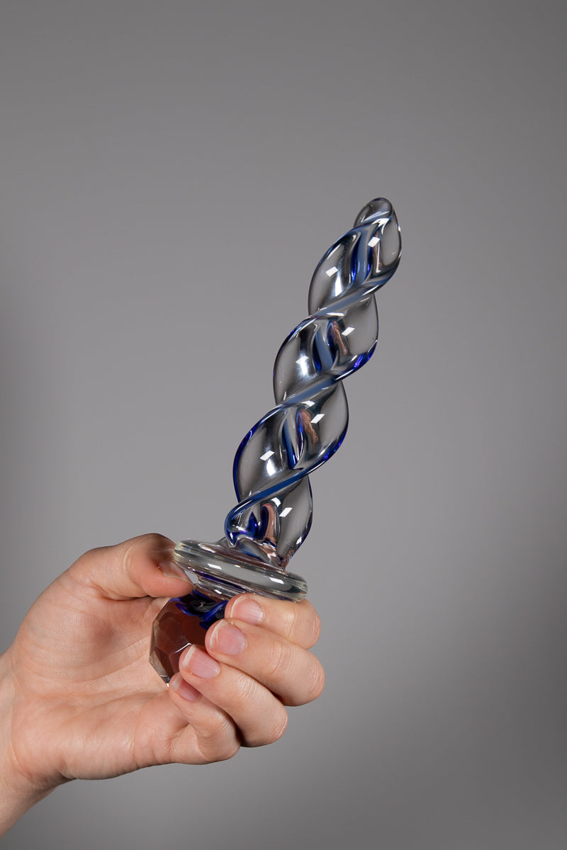 faceted implosion dildo held upright with hand holding the base