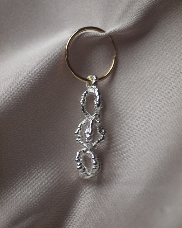 They cage earing clipped onto a silver fabric